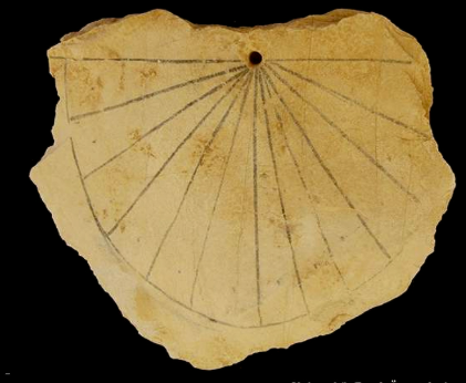 Ancient Egyptian sundial, a fan of radial lines etched into limestone.
